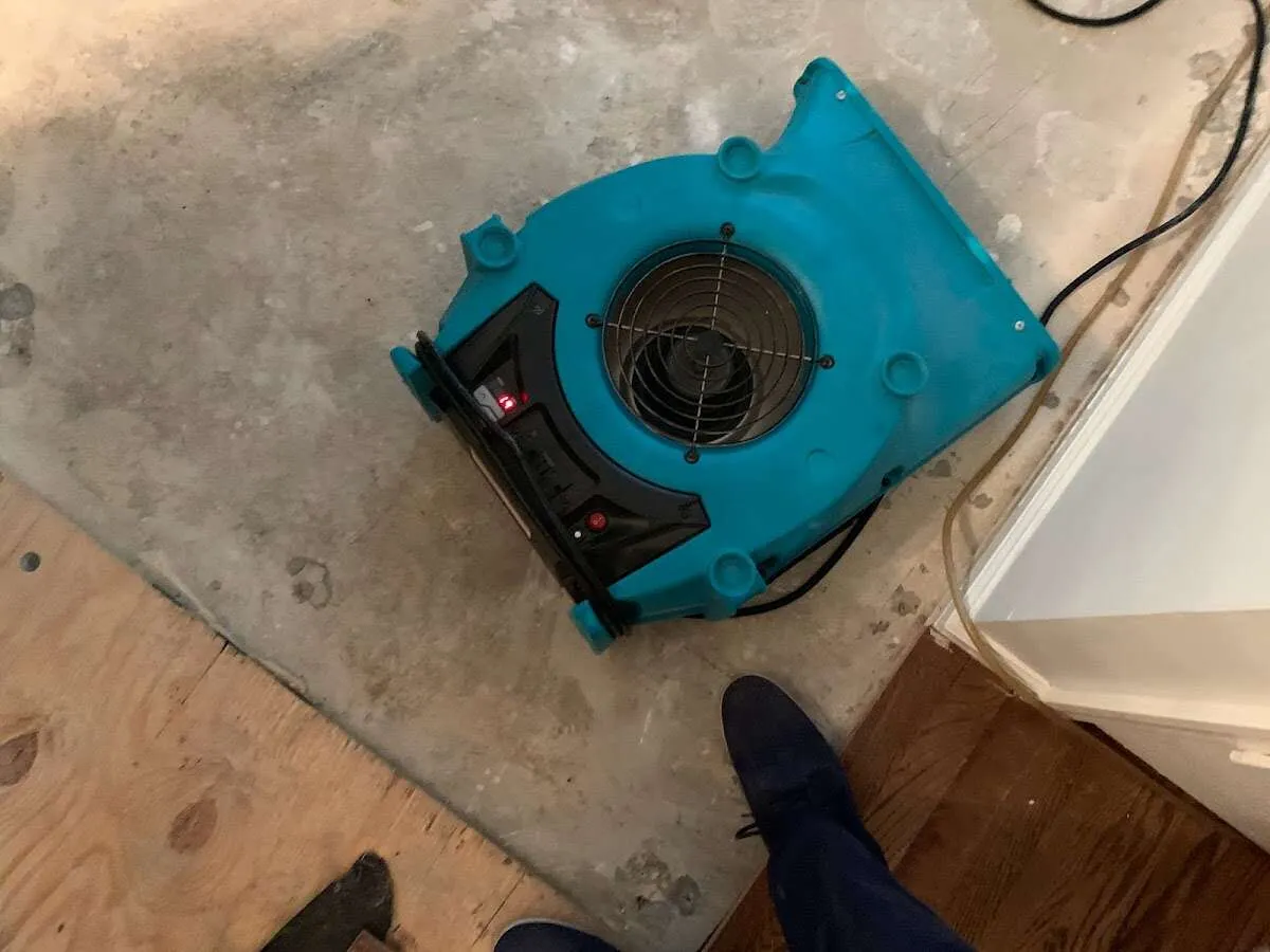 Air mover drying subfloor during Commercial Water Damage Restoration in Lumberton